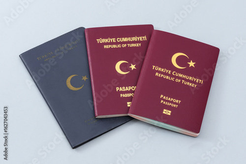 Old and New Turkish citizen public passports on the blue background.