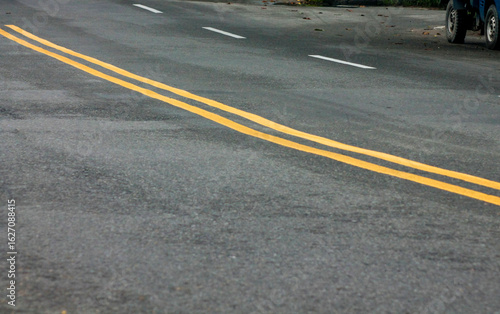 Wallpaper Mural Yellow Lines on a Winding Road. Abstract turning road background with tires track and yellow striped road marking on dark asphalt.	
 Torontodigital.ca
