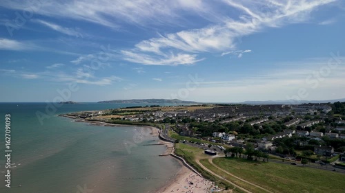 Drone turns left with views of the Malahide beach, town, and sea