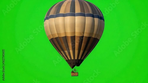 Hot air balloon gently floats against a vibrant green screen backdrop