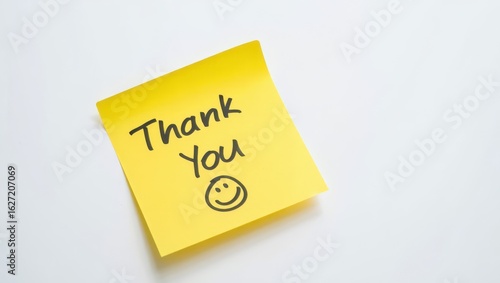 Bright yellow sticky note with handwritten thank you message and a smiley face on a clean white background