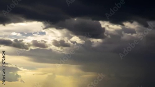 Moody Sky with Dramatic Cloud Formations and Glimmers of Sunlight Breaking Through on a Summer Day