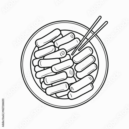 Top view of a plate filled with korean rice cakes and chopsticks for eating