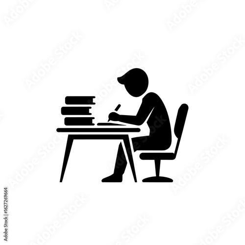 Student focused on studying diligently at a desk with books