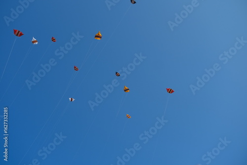 Colorful Kites Flying in Bright Blue Sky