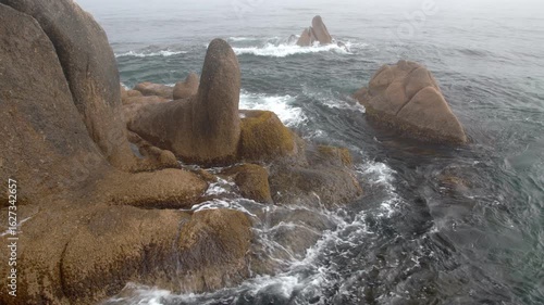 the stones overgrown with algae are drowned in the sea waves