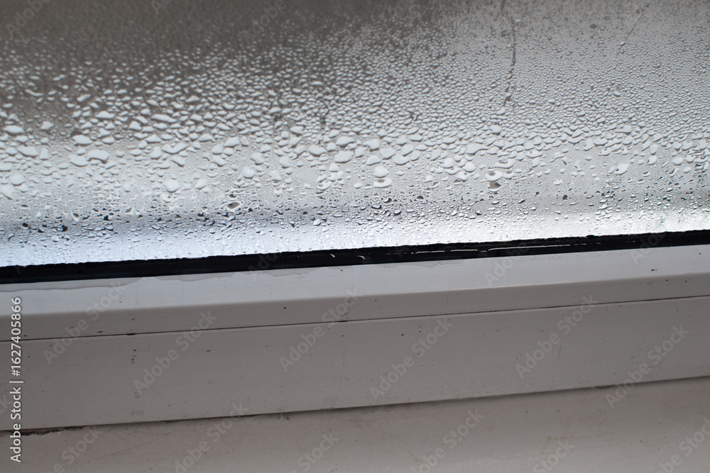 Naklejka premium dampness on the wet glass of a plastic window.