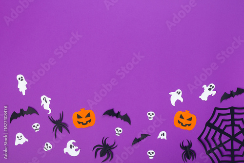 Paper crafts of pumpkins, skulls, ghosts, spiders and bats on purple background, halloween concept with copy space.