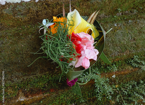 Canang Sari is a daily Balinese Hindu offering, a small woven basket or tray made of palm leaves and filled with symbolic items like flowers, rice, and incense.  
