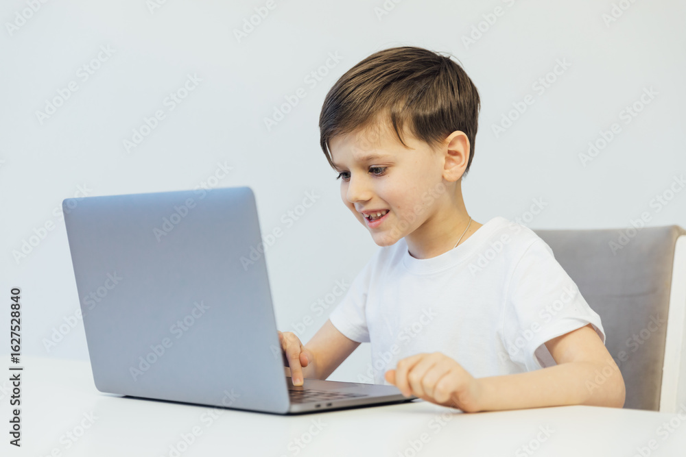 Boy working at desk with study laptop at school Boy working at desk with study laptop at school