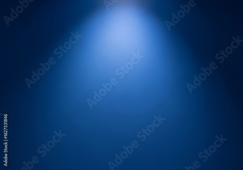 An empty deep royal blue wall background studio with soft diffused lighting from a top spotlight, perfect for product display or text.