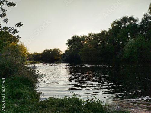 Foto Serene river view during sunset with kayaker