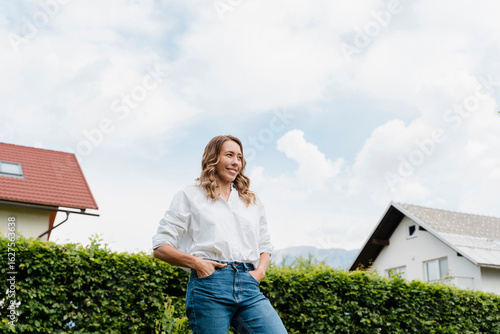 Smiling woman standing in backyard with eco living and sustainability theme