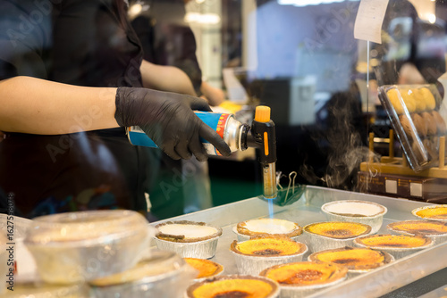 Photos Pastry chef is using a blowtorch to make egg tarts
