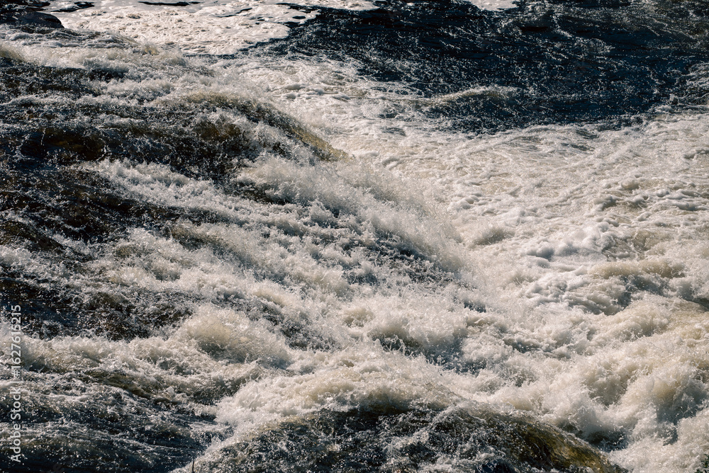 Fototapeta premium streams of clear waterfall water and stone banks of a mountain river