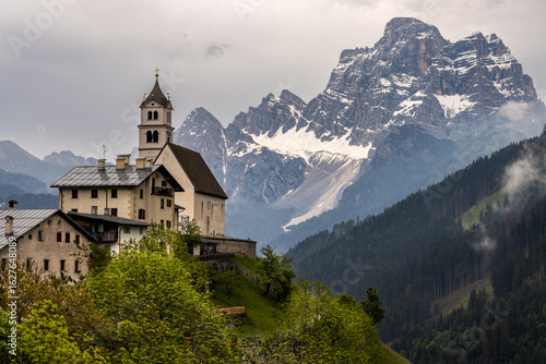 Wallpaper Mural Church of Colle Santa Lucia village perched on a cliff top with a dramatic misty and moody backdrop of Monte Pelmo in the Dolomites, Italy Torontodigital.ca