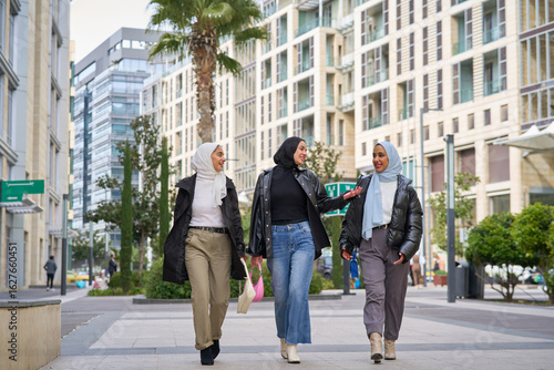 Three muslim women walking and talking in the city