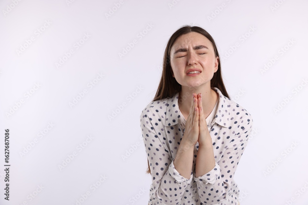 Emotional woman with clasped hands apologizing on white background. Space for text Emotional woman with clasped hands apologizing on white background. Space for text