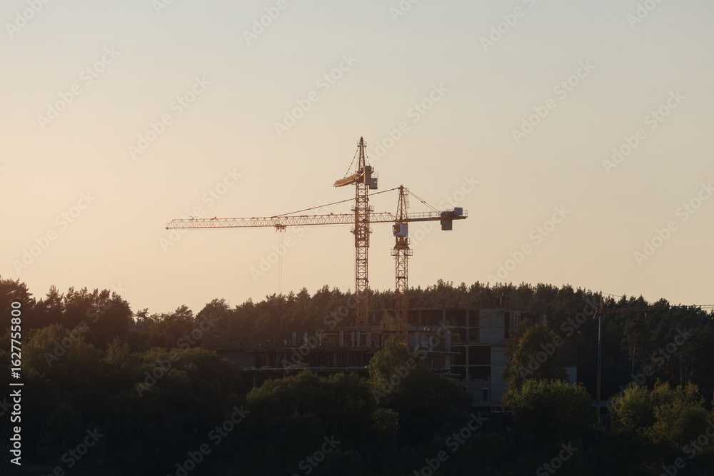 Naklejka premium Construction of buildings and high-rise cranes against the sky