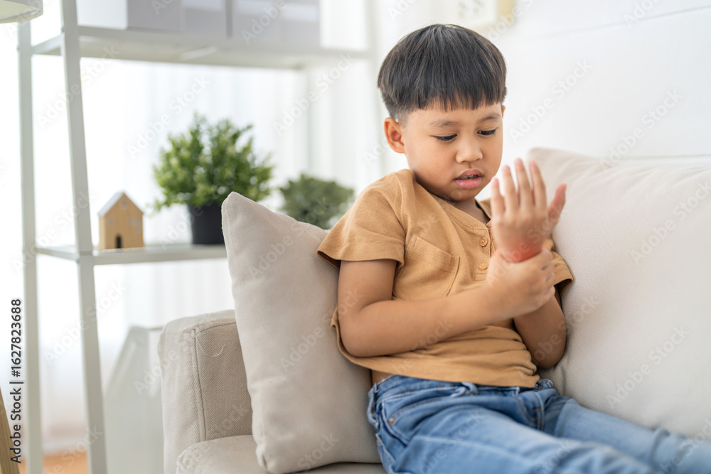 Asian boy holding injured hand with painful wrist, health care, accident or physical discomfort for childhood first aid or pain, physical injury or inflammation from fall or play, health insurance Asian boy holding injured hand with painful wrist, health care, accident or physical discomfort for childhood first aid or pain, physical injury or inflammation from fall or play, health insurance