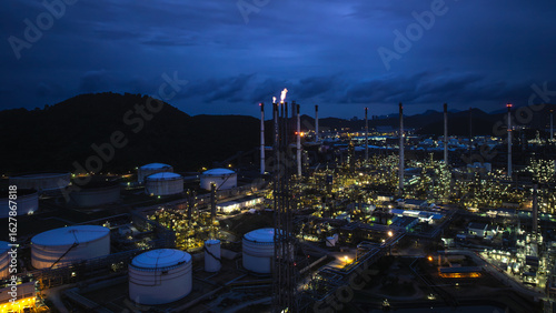 Chimney of crude oil refinery, Oil refinery plant industry factory zone, oil and gas petrochemical industrial, oil storage tank and pipeline steel, twilight scene