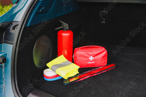 Фотография The interior of the trunk of the car in which there is a first aid kit, fire extinguisher, warning triangle, reflective vest and tow rope