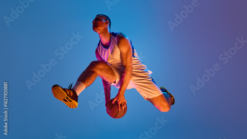 Bild auf Leinwand Basketball athlete executing aerial maneuver against vibrant backdrop