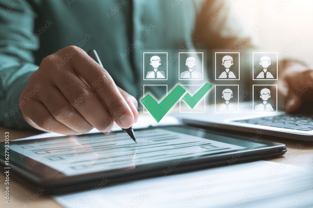 Fototapeta premium Human resources professional reviewing candidate profiles on a tablet with checkmarks