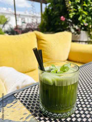 Green Cocktail with Fresh Mint on Garden Patio. Summer Season Green Drink in a glass with a straw