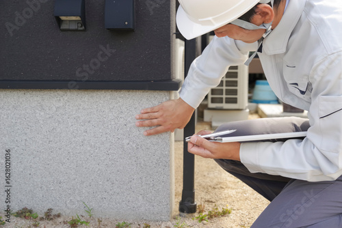 Foto 住宅の基礎部分をチェックする男性