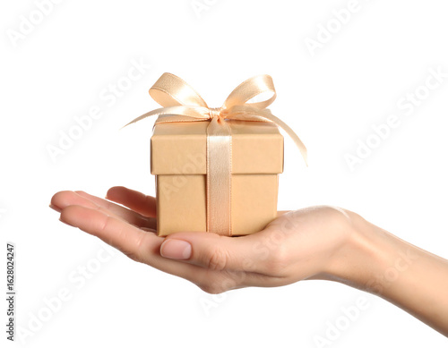 A hand holding a small beige gift box tied with an elegant ribbon and bow.