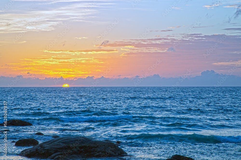 Obraz premium Sunset over Kata Beach with rocky shore Phuket