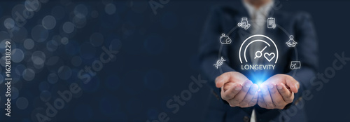 Longevity and wellness, longevity economy. Holds a glowing digital interface featuring icons related to longevity, health and wellness. Longer, healthier life through lifestyle and medical choices.