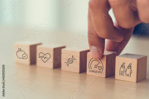 Health and longevity, longevity economy concept. Wooden blocks with icons related to health, genetics, aging and longevity. A holistic approach to a healthy lifestyle and extended life expectancy.