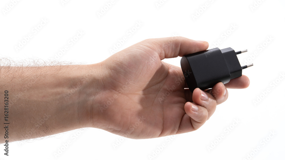 Person holds a black charger in a hand Person holds a black charger in a hand