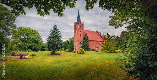 Panoramic summer view of red briks St.-Johannis Church. Splendid morning cityscape of Kruckow village, Germany, Europe. Traveling concept background.