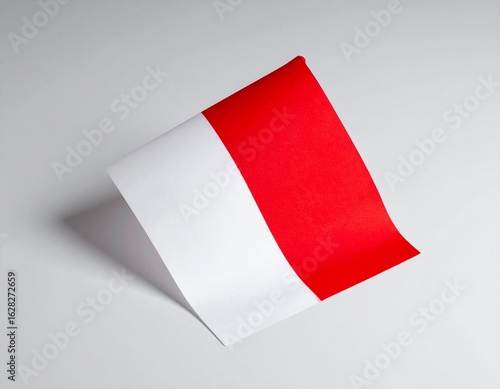 Wallpaper Mural A small Indonesian flag rests on a light gray surface, casting a subtle shadow. Torontodigital.ca