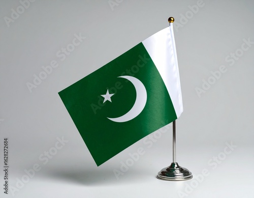 Wallpaper Mural A small Pakistani flag on a metallic stand is displayed against a neutral background. Torontodigital.ca