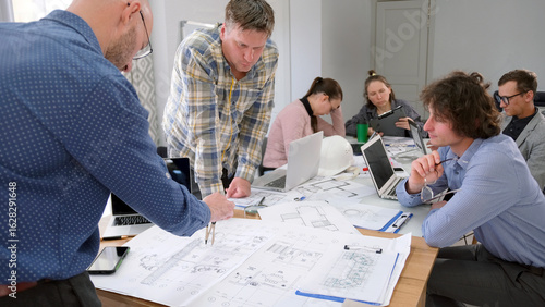 A group of specialists discusses construction issues. Engineers, designers and architects are working together on a smart home project