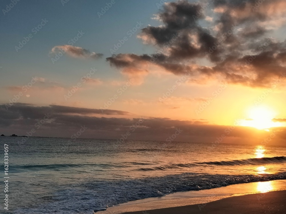 Obraz premium Sun setting behind clouds over North Coast waves