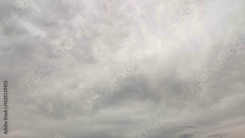 Timelapse of an overcast sky background covered with moving gray cloud texture