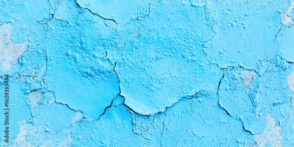Fototapeta premium Cracked blue wall texture with peeling paint creating an abstract pattern. Weathered surface, texture focus