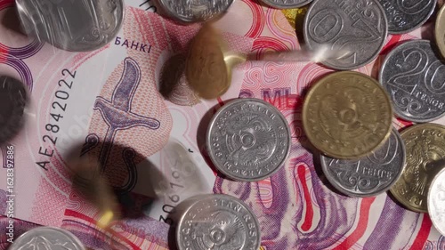 Tenge coins of different denominations fall on banknotes