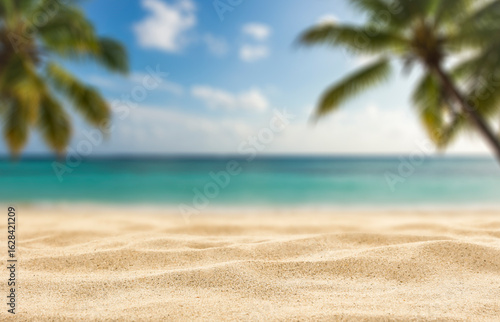Fototapeta Naklejka Na Ścianę i Meble -  Minimalist summer composition of warm golden beach sand with natural space for product placement or text overlay. Blue sky, sunlight and sea view with creative marketing summer vacation concept.