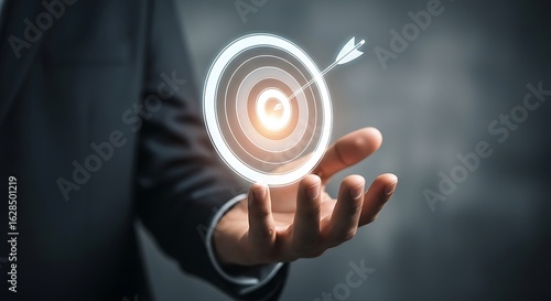 Hand holding glowing target with arrow hitting bullseye success concept image photo