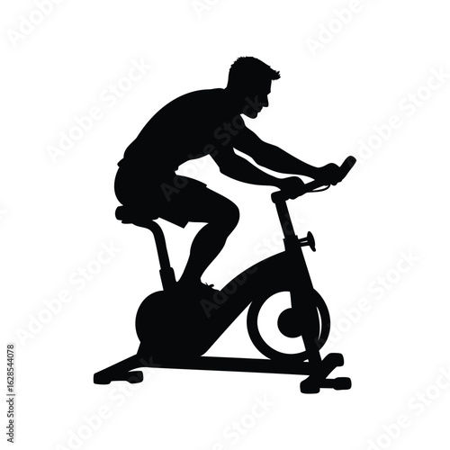 Silhouette of a man working out on an exercise bike indoors