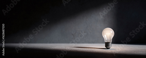 Single glowing lightbulb on a dark background. Represents ideas, inspiration, innovation, and solutions. Great for business, education, and creative projects.