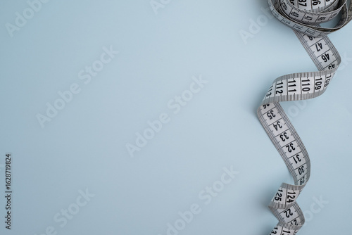 Measuring tape on a light background. Tool for measuring length and volume. Tape for measuring in the clothing industry or the volume of the human body  
