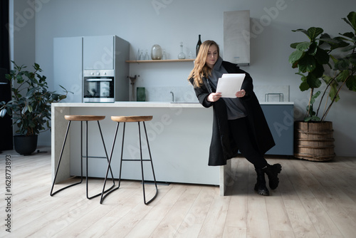 Canvas Print Confident woman arriving at a modern apartment with luggage, potentially a tenant or property owner reviewing new real estate