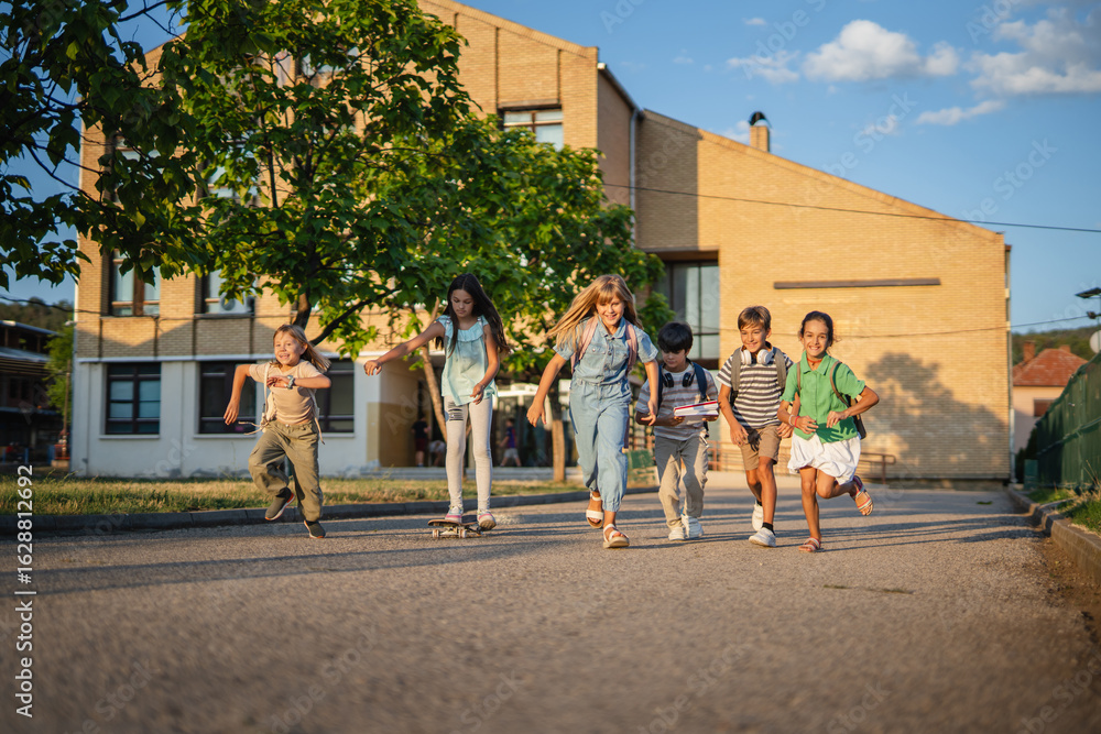Obraz premium Group of elementary school students running and skateboarding after school